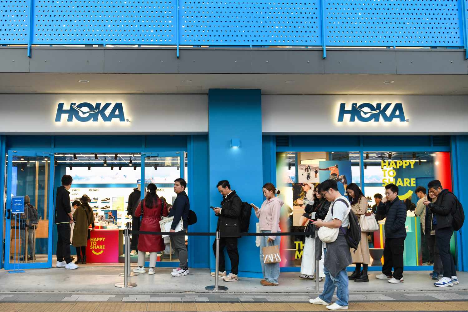 Shoppers stand near a Hoka store.