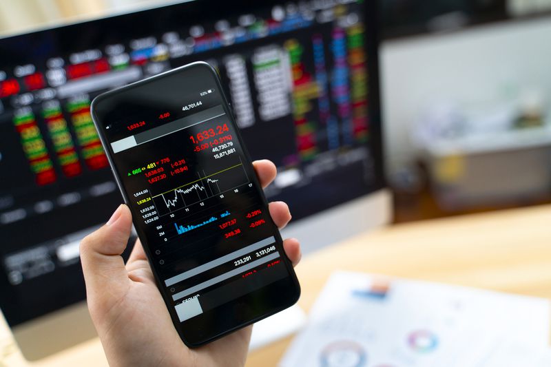 Hand Holding Smart Phone Displaying Stock Market Data