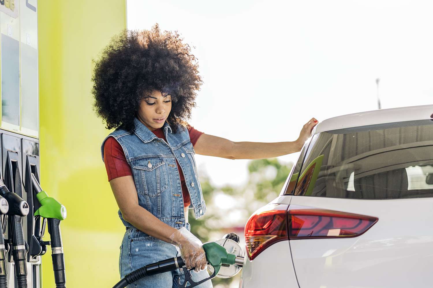 A woman fills her car with gas. 