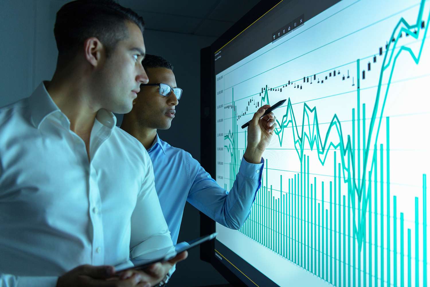 Businessmen Studying Graphs on an Interactive Screen in a Business Meeting