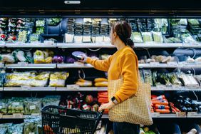 A woman shops in the produce section of a grocery store