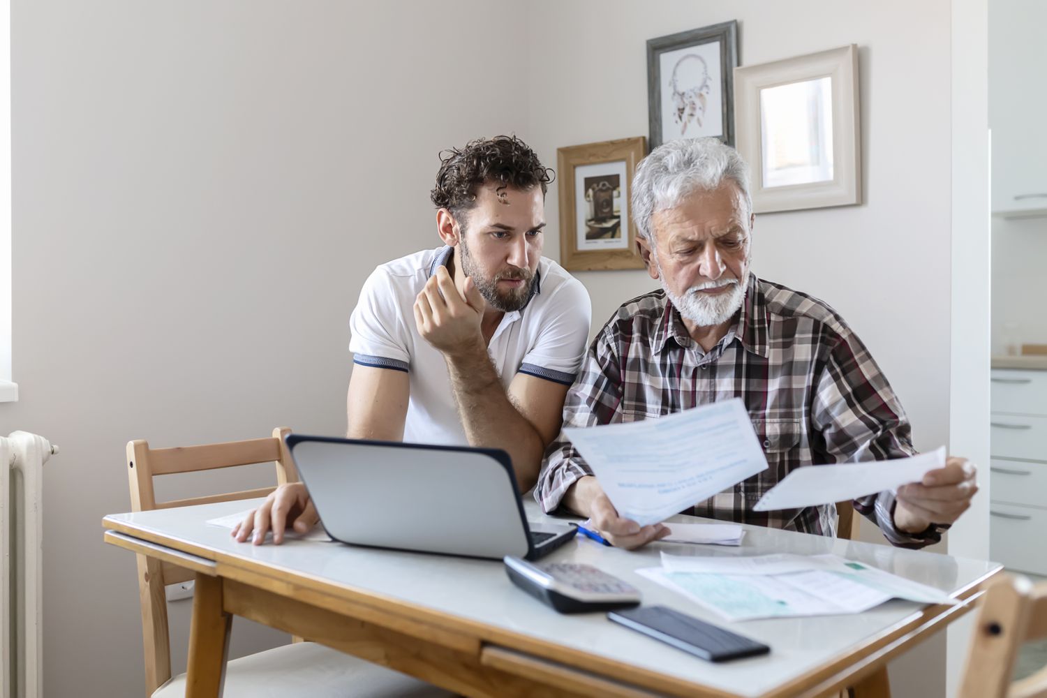 Dad and son doing finances together to stop foreclosure on the house's reverse mortgage.