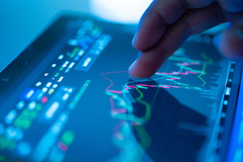 Cropped hand using a tablet showing financial data