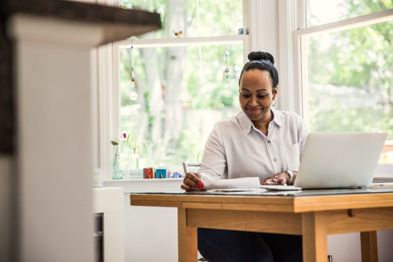 Woman working on laptop in kitchen