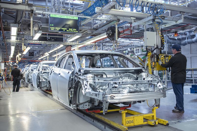 Workers on car production line in car factory.