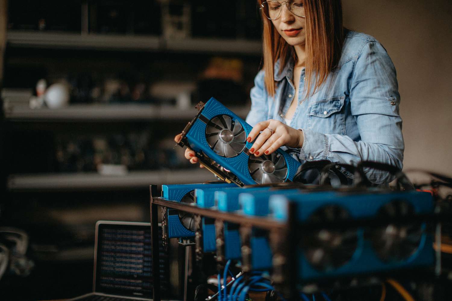 A hardware engineer replaces a fan in a cryptocurrency mining machine.