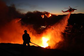 Firefighters battle flames in Pacific Palisades, Calif., on Tuesday.