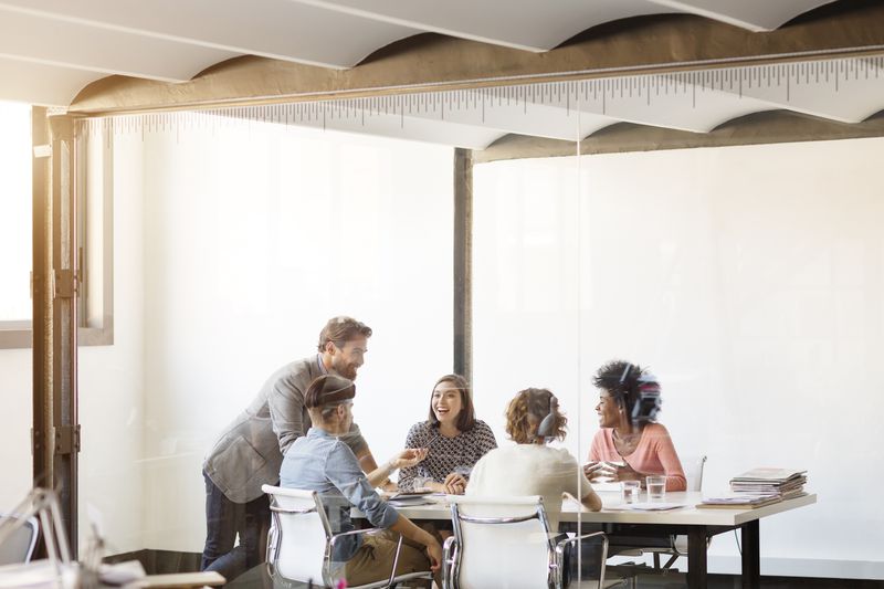Young business colleagues in a boardroom talking and smiling