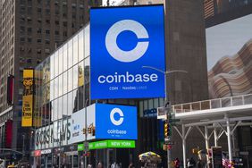 Coinbase billboard in an urban area with surrounding buildings and advertisements