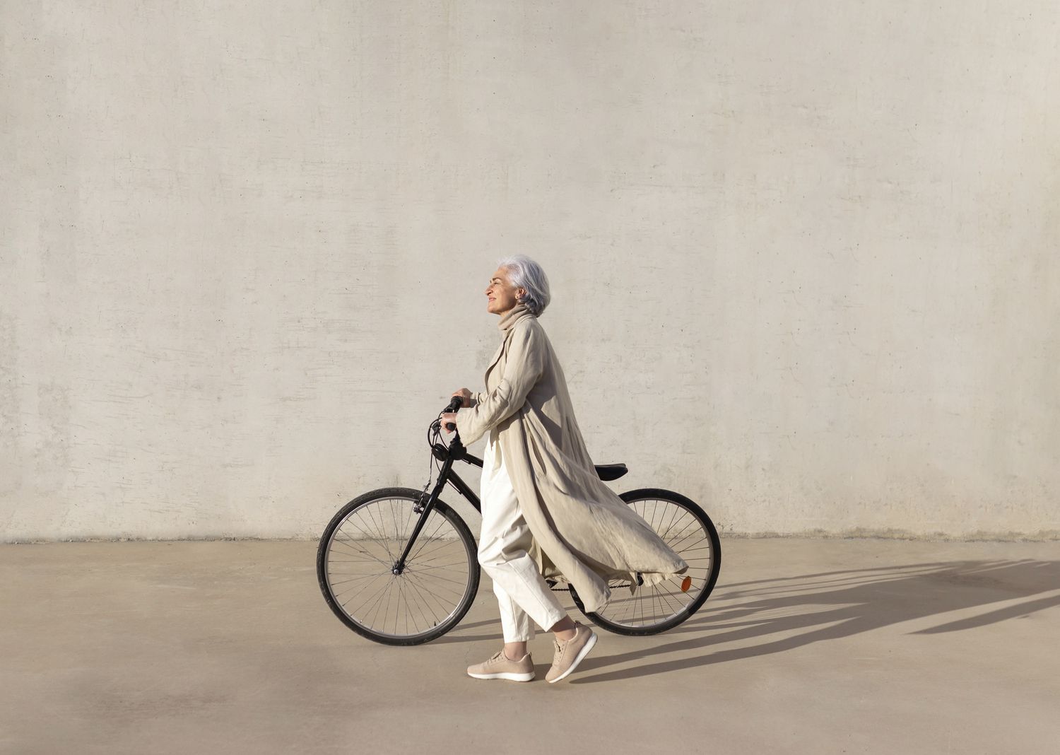 A person leading a simple lifestyle is walking with a bicycle on a sunny day