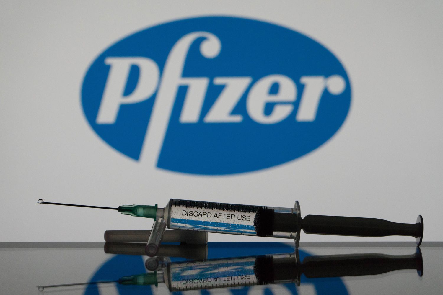 Pfizer logo behind a syringe