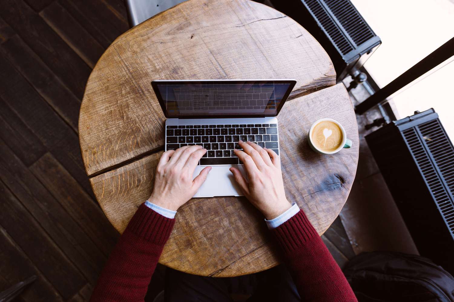 A man working on laptop in coffee shop.