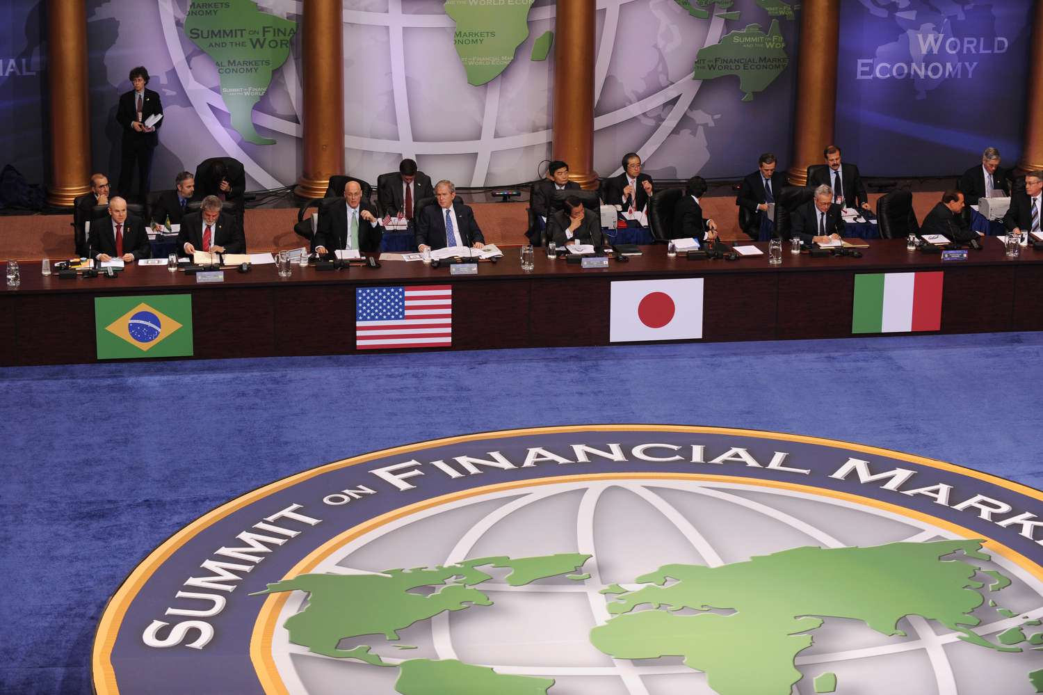 U.S. President George W. Bush (4th-L) and Secretary of the Treasury Henry Paulson (3rd-L) look on while world leaders including Brazil's President Luiz Inacio Lula da Silva (2nd-L), Japanese Prime Minister Taro Aso (5th-L) and Italian Prime Minister Silvio Berlusconi (2nd-R) gather at the Summit on Financial Markets and the World Economy at the National Building Museum on November 15, 2008 in Washington, DC. Twenty world leaders are gathered at the summit to address problems currently impacting the global economies. 