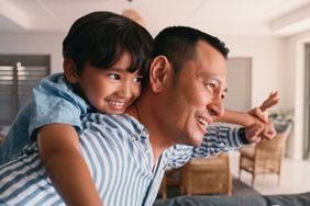 Flying, child and dad with piggyback for playing in home with bonding, fun game and support with smile. Family, man and boy kid on shoulder for airplane fantasy with imagination, trust and freedom
