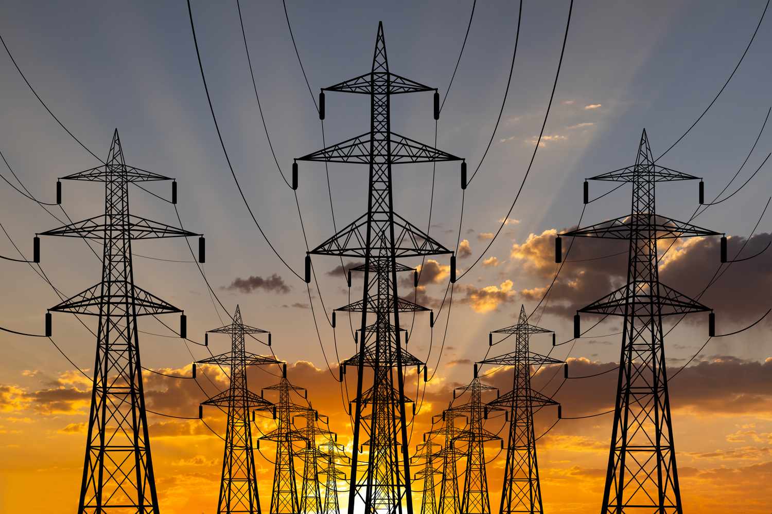 Rows of utility poles and wires at sunset