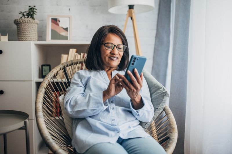 Older woman in living room with smartphone