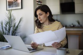 Young woman going through her finances at home