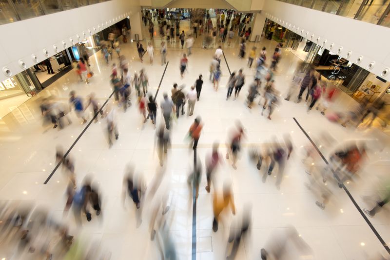 A photo illustration of blurred shoppers in a mall. 