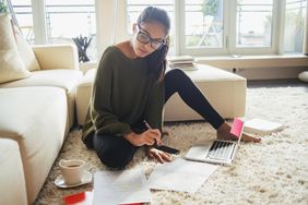 A young woman writes an abstract on a laptop surrounded by her notes and research. Learn how to write an abstract here.