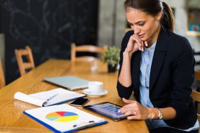 An investor sits at a table and reviews various charts