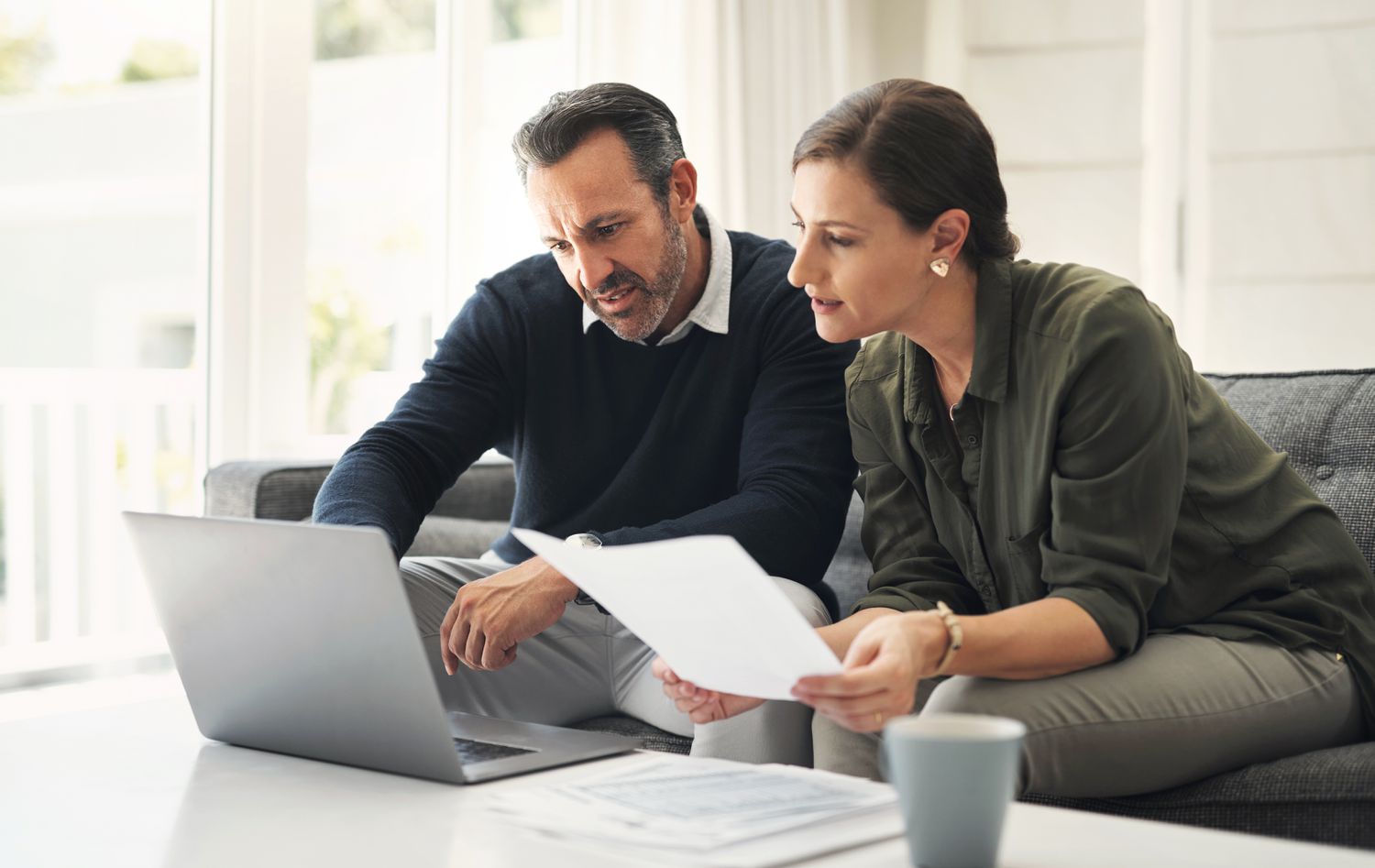 Two people reviewing something on a laptop screen
