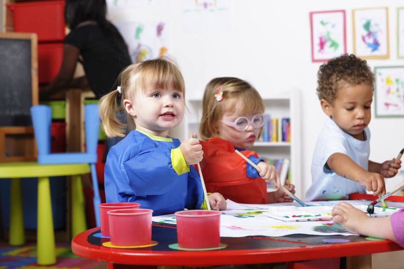 Toddlers painting at day care