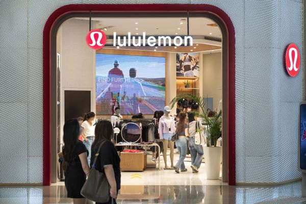 People walk near a Lululemon store. 