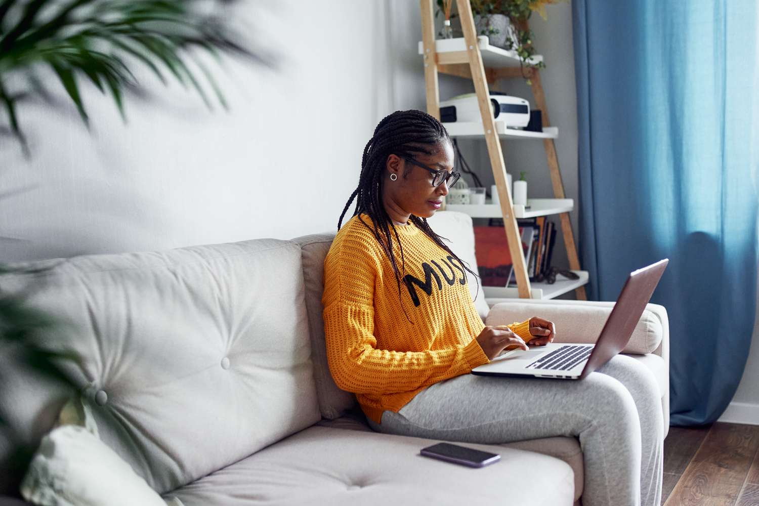 A woman sits at a computer, considering her finances.