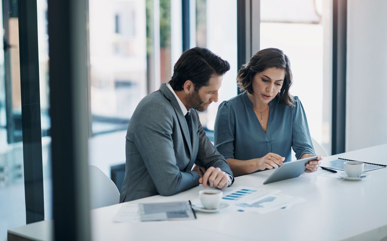 Two colleagues at a table with a tablet