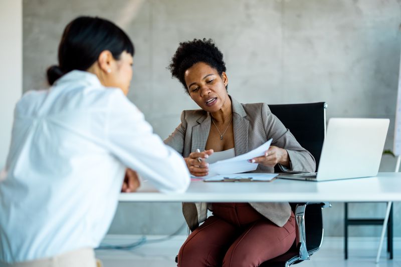  A Human Resources representative discussing tax-deferred savings plan options with a new employee.