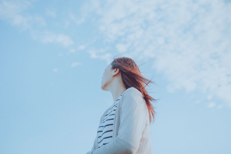 Single woman with a backdrop of the blue sky.