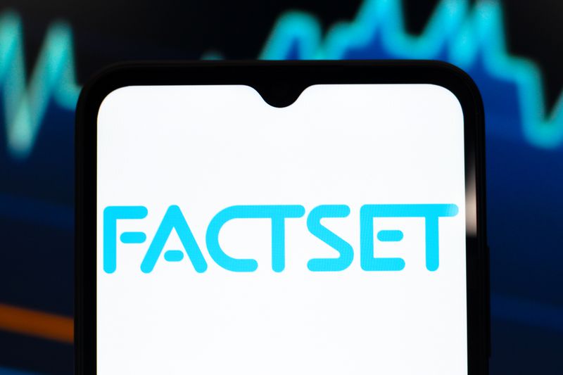 The blue FactSet logo is seen on a phone screen, with a stock chart in the background.