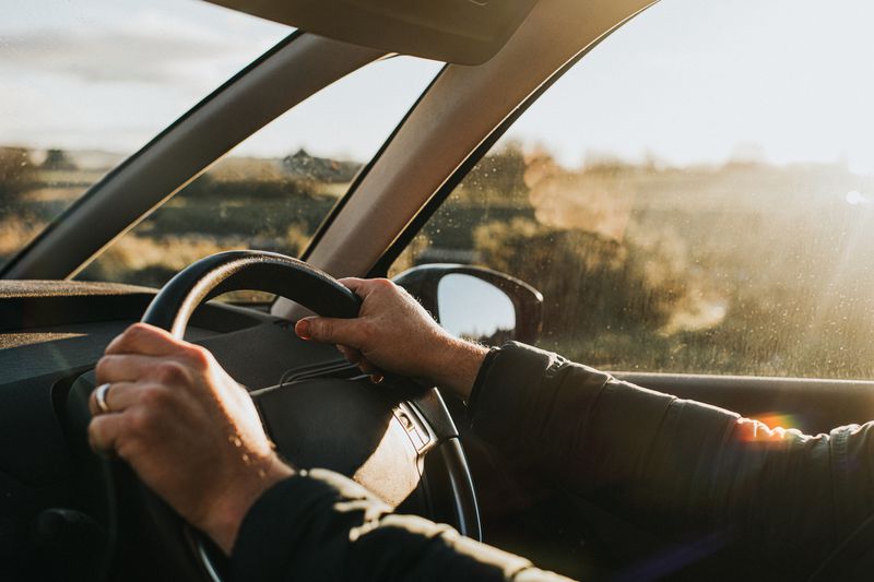 Hands holding a steering wheel in a car
