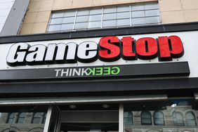 The white and red GameStop logo is seen above the entrance to a store.