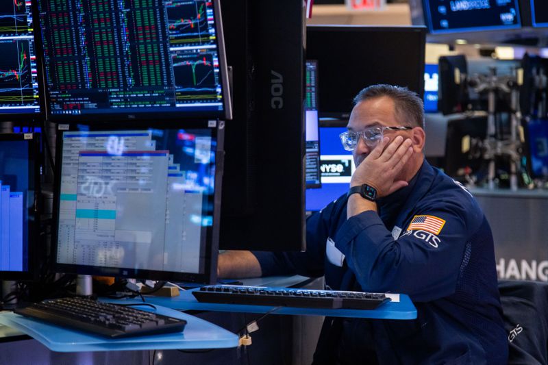 A stock trader on the stock exchange floor watching trades on a computer