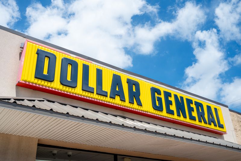 The black and yellow Dollar General logo is seen on a sign above the entrance to a building.