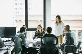 Businesswoman leading a meeting in an office huddle 
