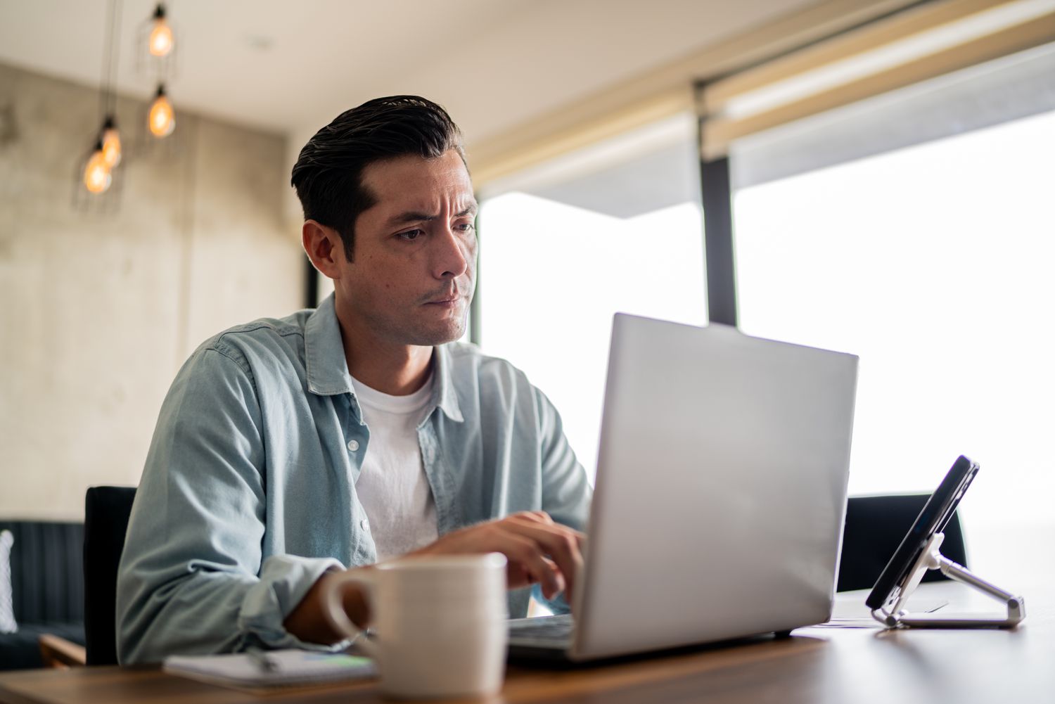 Homeowner checking interest rate history and the news to decide whether to lock the current mortgage rate or not.