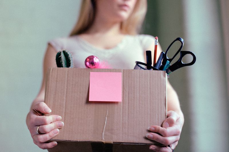 Woman holding a box of her office supplies.