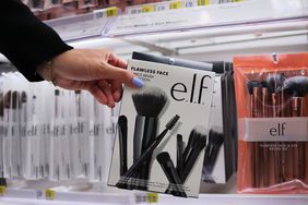 A customer reaches for an E.l.f. product. 