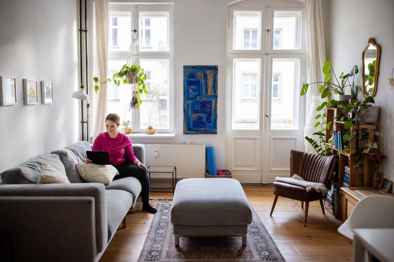 Homeowner sitting at home in the living and looking up home equity loan.