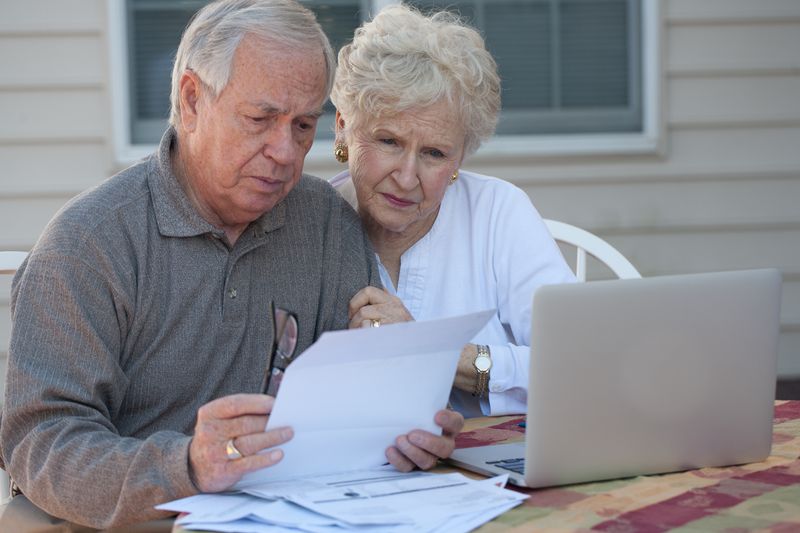 Couple working at a computer with concerned expressions on their faces