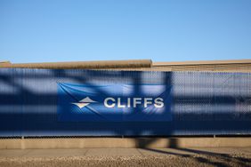 The blue and white Cleveland Cliffs logo is seen on a fence outside a building.