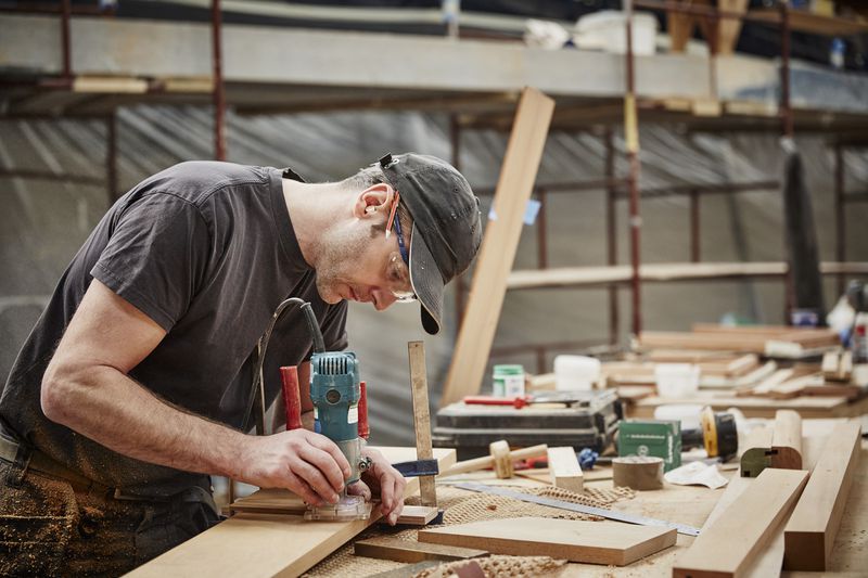 craftsman using electric tools on wood