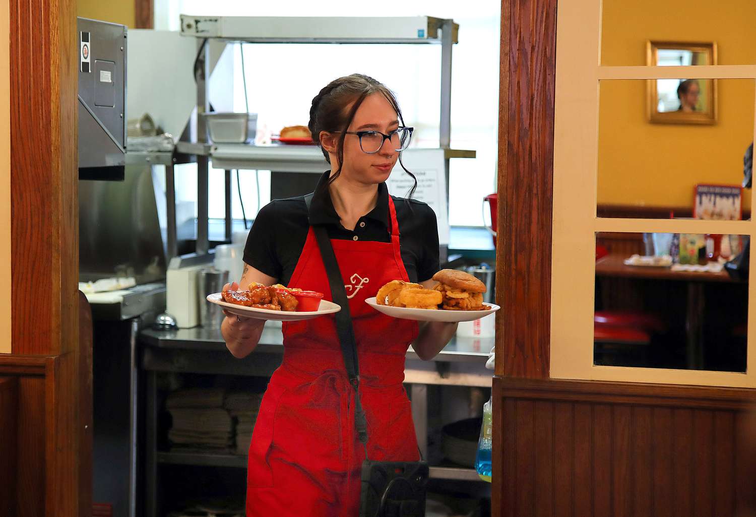 Waitress Eliza Helin brings out an order from the kitchen at Friendly's in Northampton, Massachusetts.