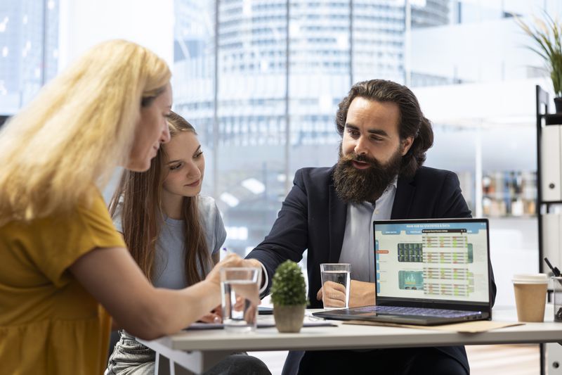 Financial advisor explaining a detail to two clients.