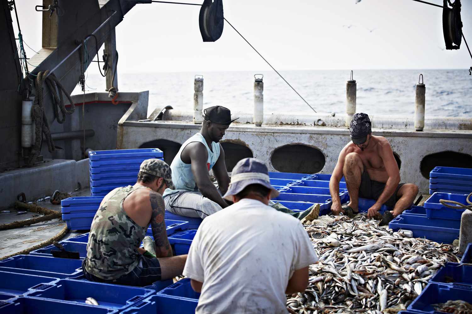 Fishermen working together on fish trawler