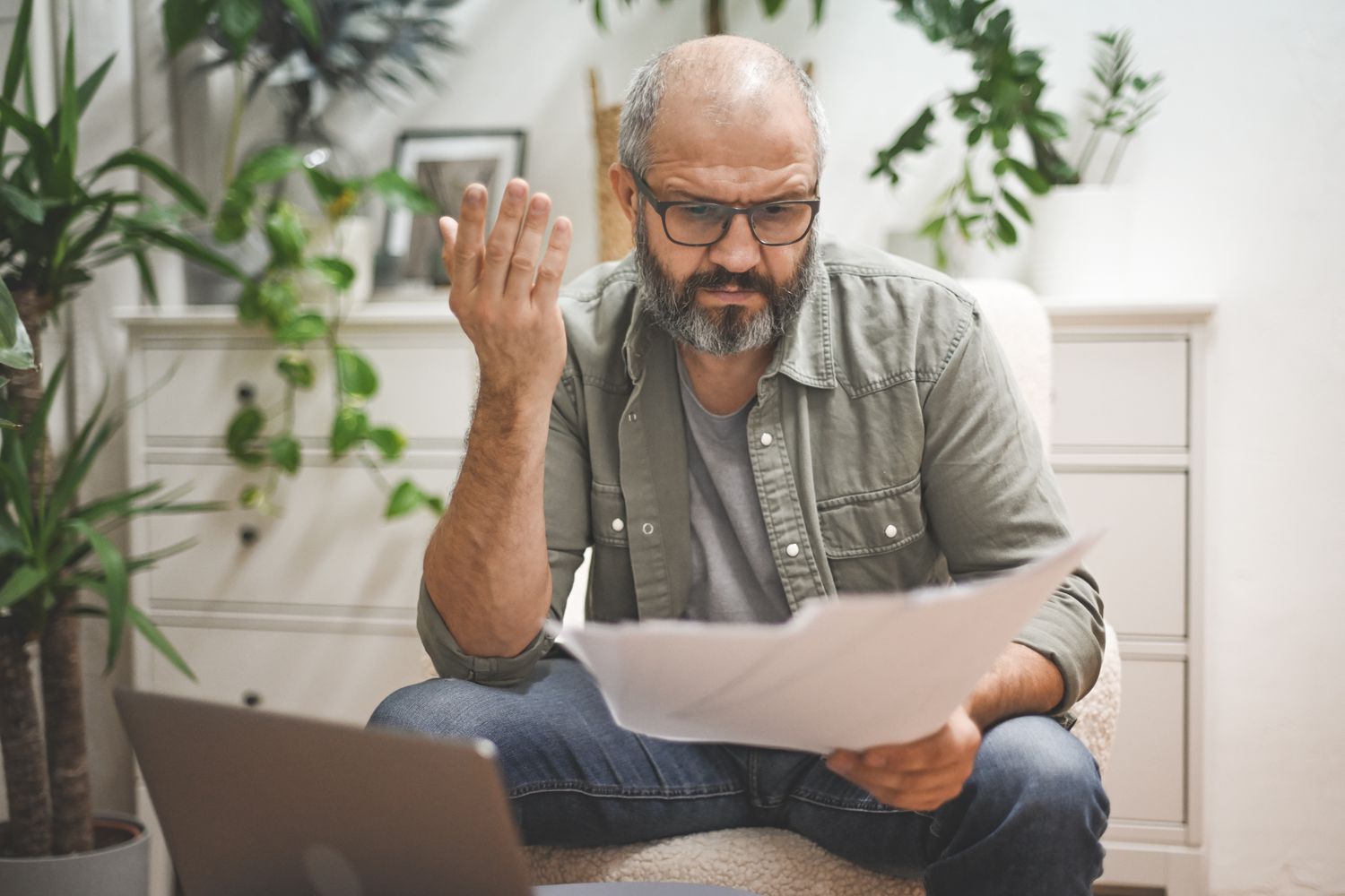 A worker looks confused as they review their pay statement showing a greater amount of taxes were withheld.