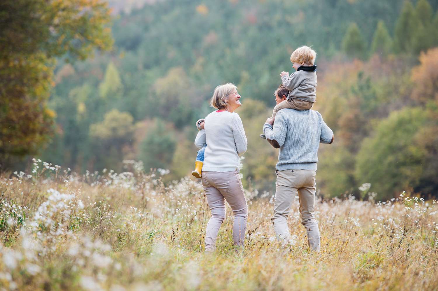 Two older adults with toddlers outside