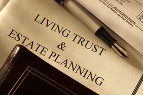 Close-up of fountain pen with living trust and estate planning documents